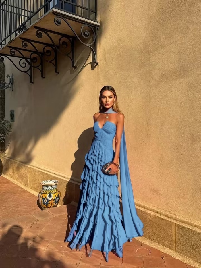 Woman in a soft blue tiered gown with cape