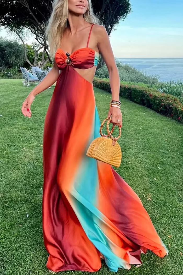 Woman in a sunset ombré maxi dress by the sea